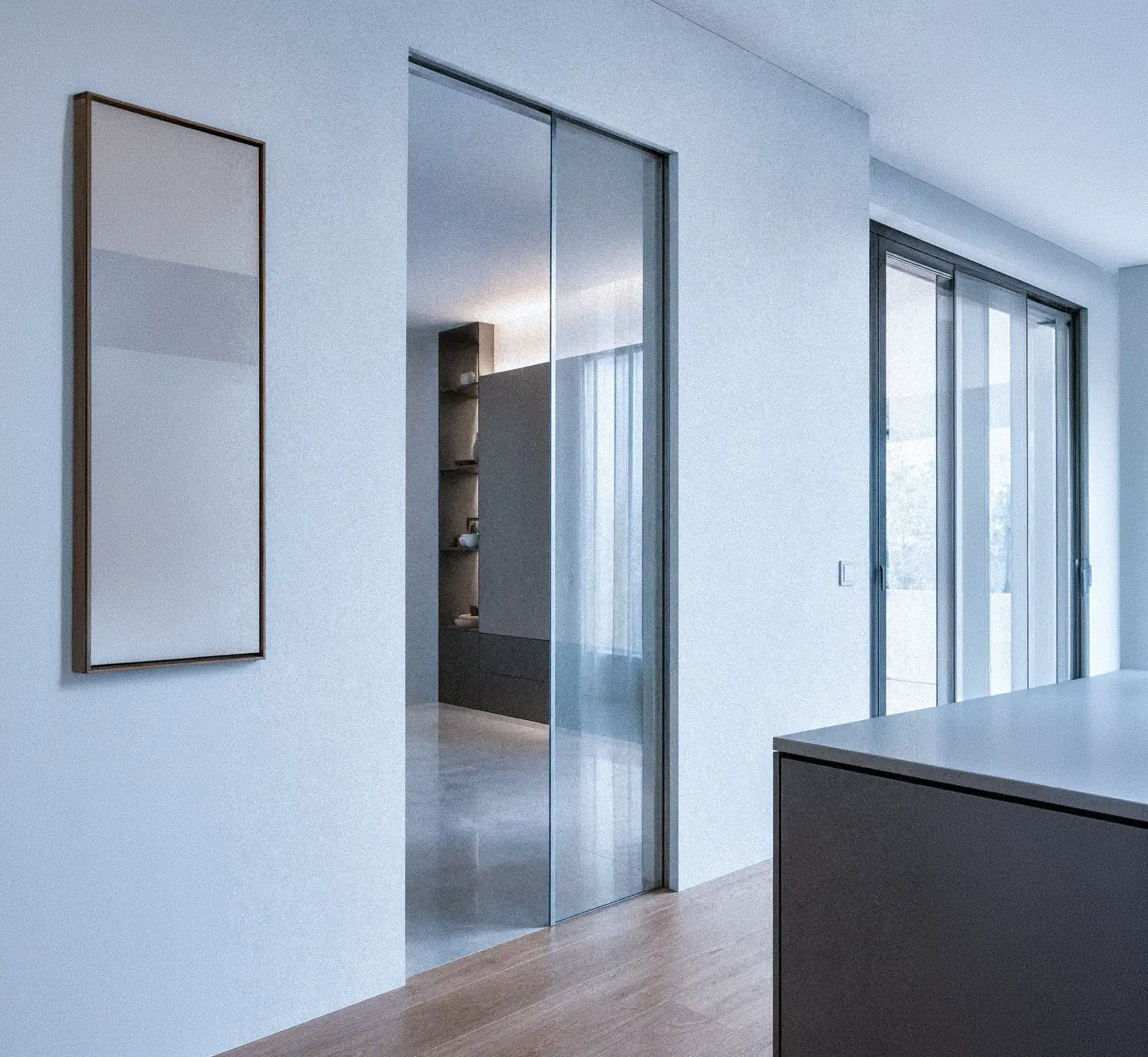 Porta in vetro tipo scrigno con controtelaio metallico e scorrimento fluido silenzioso.