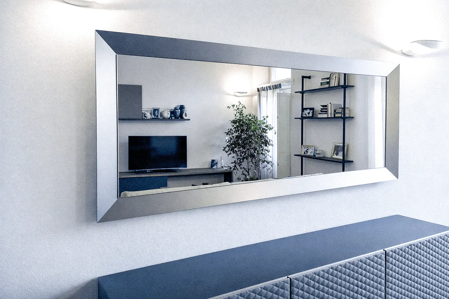 Specchio su misura a parete per corridoio con fissaggio invisibile e bordi a filo lucido.